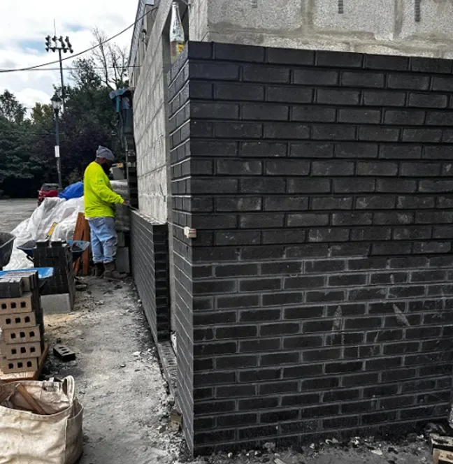 Dark brick veneer going up on a building